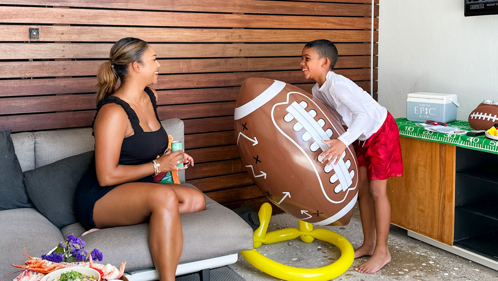 mom and child in game day soccer cabana with table full of snacks and giant football
