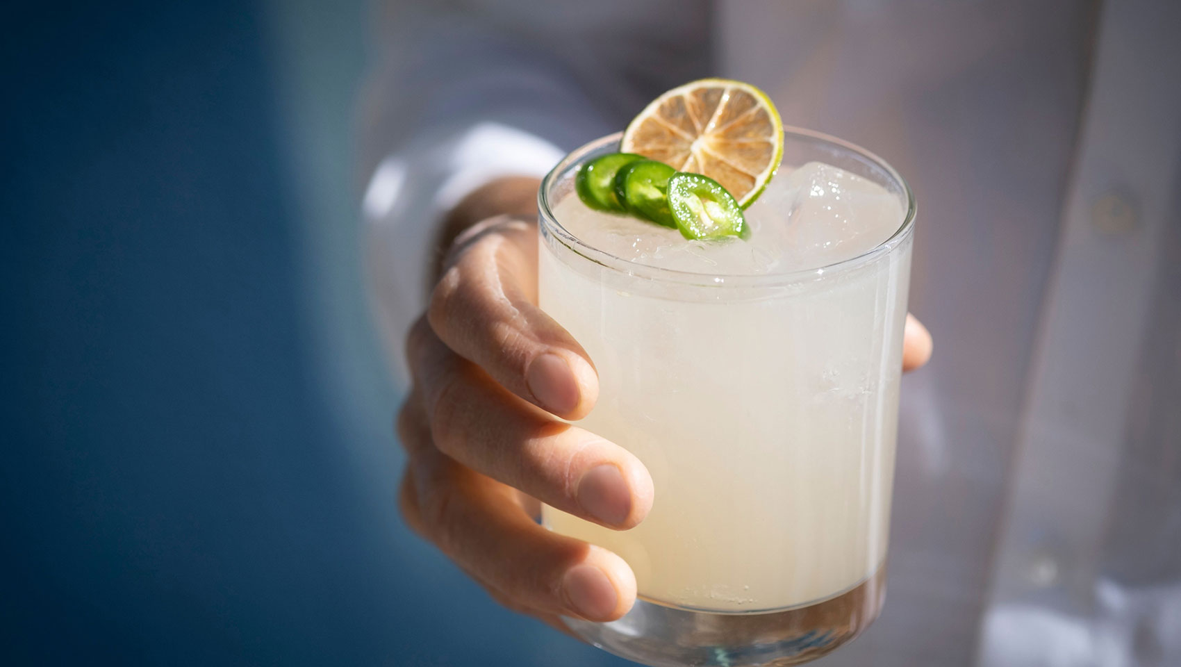 cocktail with lime and jalapeno garnish